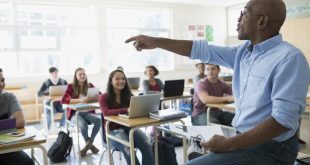 High school teacher calling on student in classroom